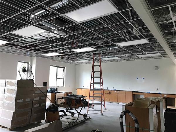 Classroom in three-story addition getting finishing touches of casework, ceiling grid and lighting